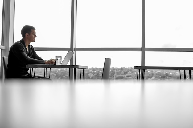 A businessman working in an office with large windows