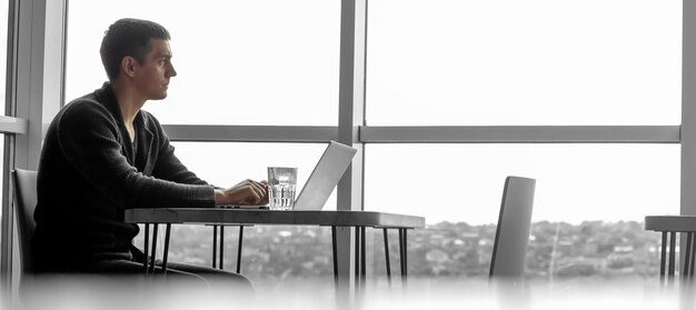 A businessman working in an office with large windows