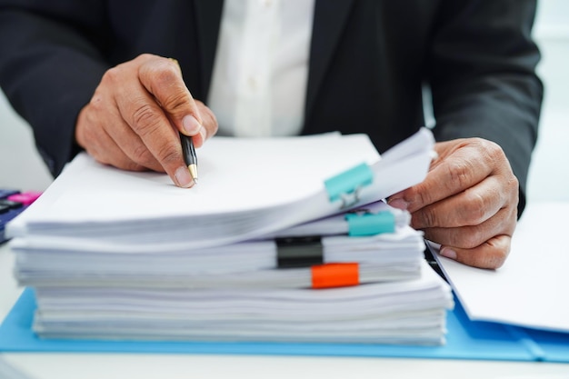 Businessman working and prepare report data to analysis
information in file binder at office