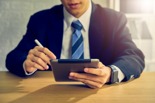 Businessman working on tablet at the table in office.