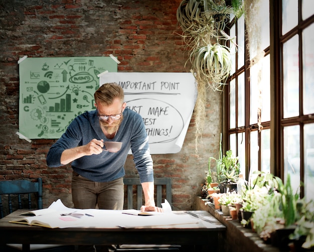 Businessman working while having a cup of coffee