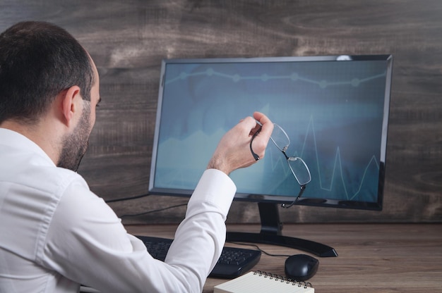 Businessman working with analytics sitting at the working place with computer Graphs and charts on computer screen Business Finance Accounting