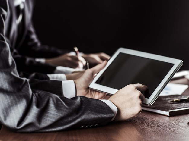 Businessman working with digital tablet at workplace.