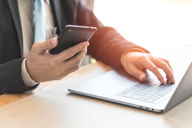 Uomo d'affari che lavora con laptop e telefono