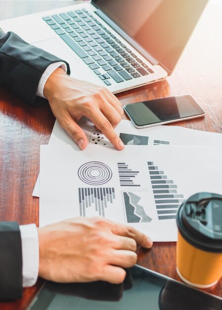 Businessman working with laptop and smartphone on wooden table