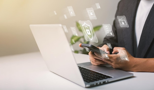 A businessman works on his laptop at home with a virtual display showing a symbol to signify cyber security privacy and online data protection