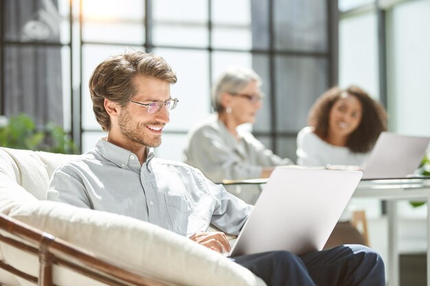 Businessman works on a laptop while sitting in an office chair