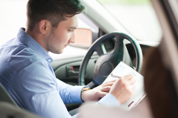 L'uomo d'affari scrive nella sua nuova automobile