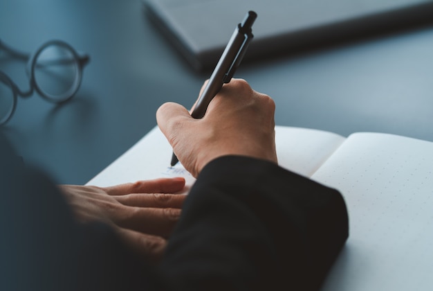 Photo businessman write on notebook on desk in office