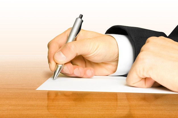 Photo businessman writes a pen on an empty paper