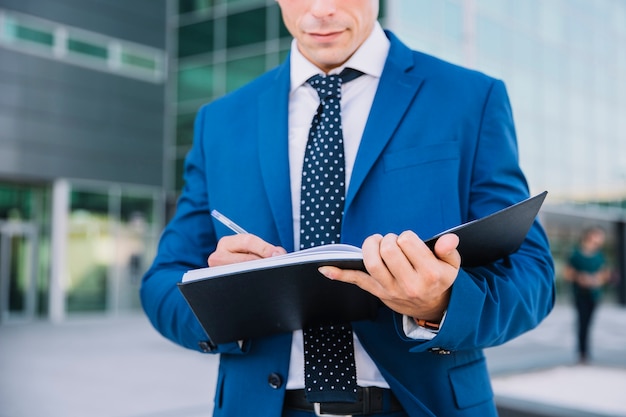 Photo businessman writing in folder