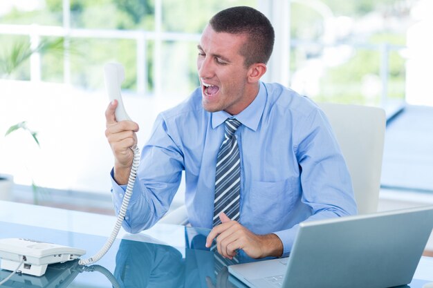 Businessman yelling at his phone