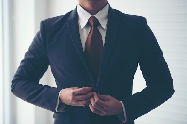 Businessmen are tying necktie. To prepare for the presentation