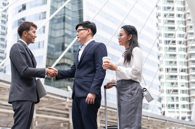 Businessmen and business woman shaking hands during a meeting with reach an agreement for businessHandshake Gesturing People Connection Deal Concept