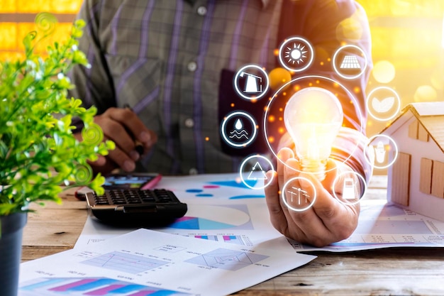 Businessmen calculate electricity bills using a calculator graph document energy resources icon Earth day Energy saving concept Renewable energy and energy sources of the world