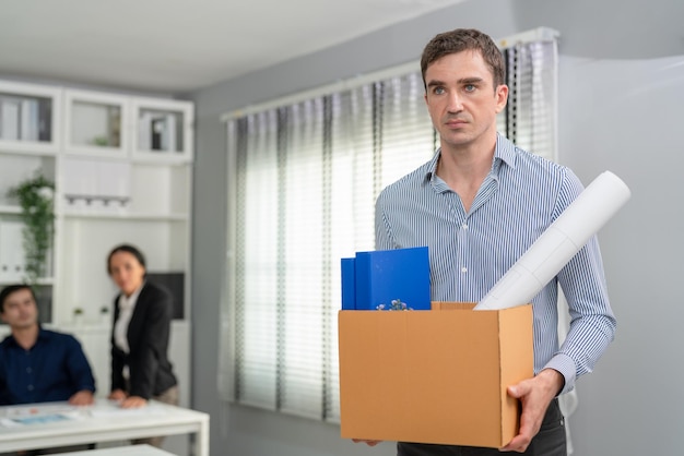 Businessmen feel sad carrying cardboard boxes walking from
office after resign being fired