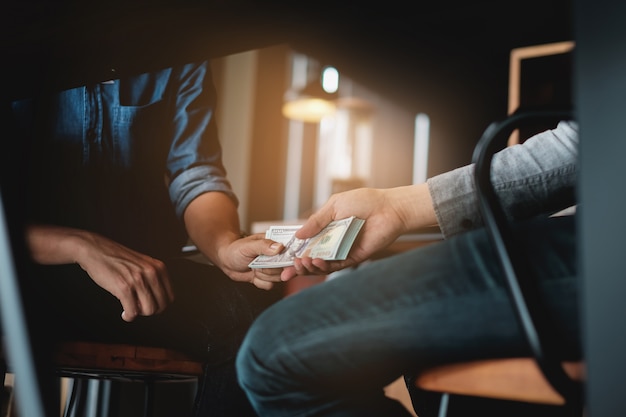 Photo businessmen giving bribe money under table