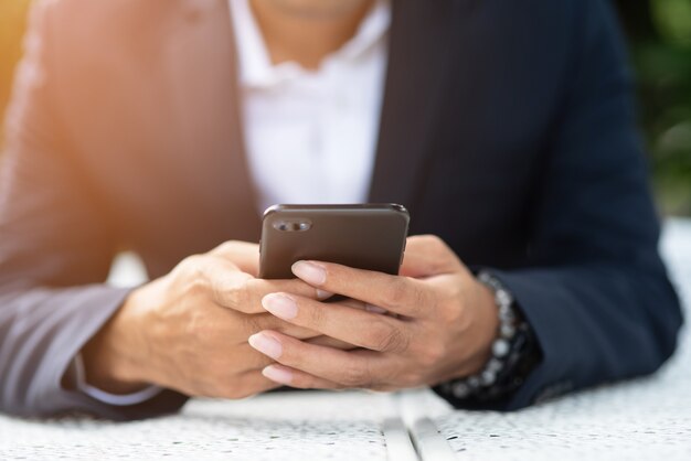 Businessmen hold the phone to check email on the internet.