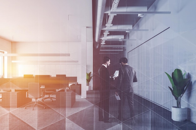 Businessmen in interior of modern office with white walls, carpeted floor, rows of gray computer tables with chairs and lockers near the wall. Toned image double exposure