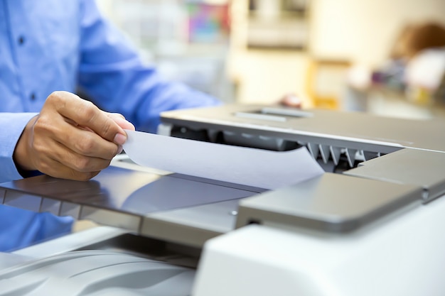 Photo businessmen load paper in the copier and useing photocopier or printer for printout, scanning, exrox documents papers at office.