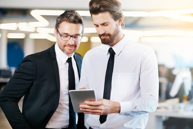 businessmen looking at digital tablet in office