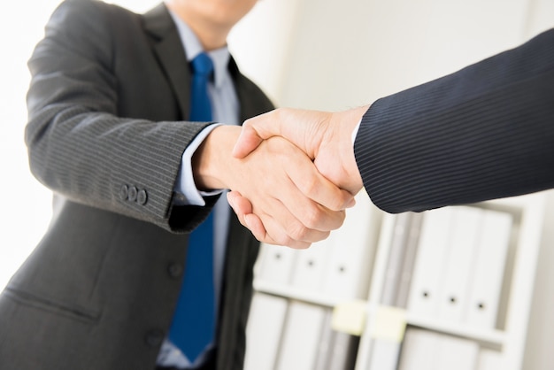 Businessmen making handshake in the office