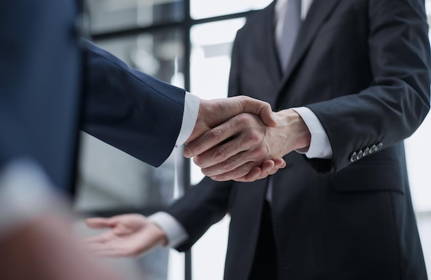 Businessmen meeting and handshake in front of business center buildings