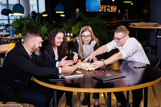 Businessmen play jenga Business holiday concept Young people play board games in the office