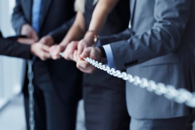 Businessmen pulling chain teamwork togetherness concept