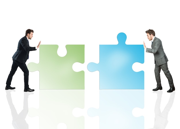 Businessmen push a pieces of puzzle fit together