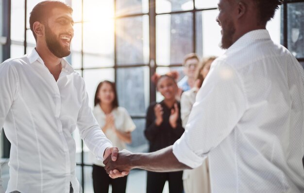 Businessmen reach out to each other to shake hands