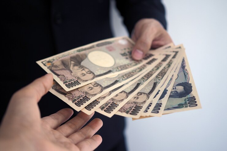 Photo ビジネスマンは従業員に日本の紙幣を送ります。
