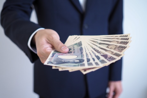 Businessmen sending Japanese yen notes