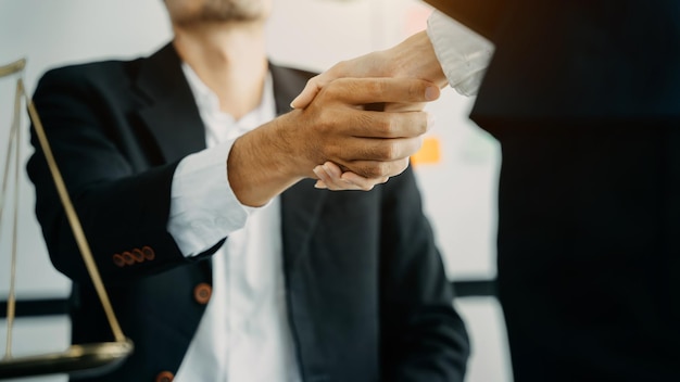 Businessmen shake hands after agreeing to start a new project\
successfully