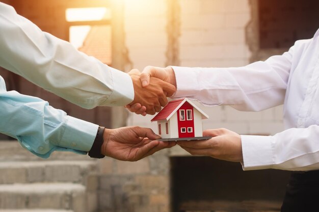 Businessmen shake hands and agree to buy and sell houses