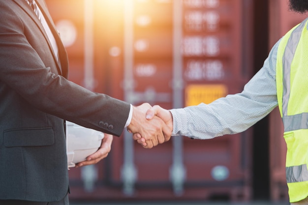 Businessmen shake hands to agree on trade and investment Business of import and export of goods by sea freight system