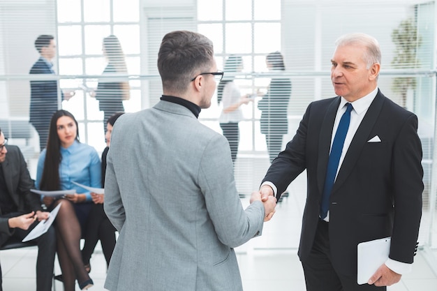 Businessmen shake hands standing in the conference room. concept of cooperation