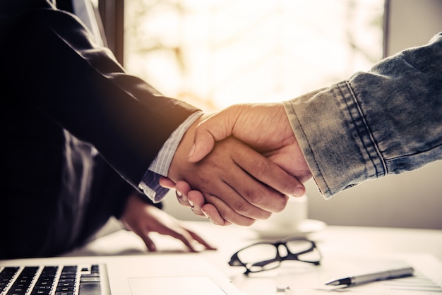 Businessmen shake hands with successful partners and congratulate