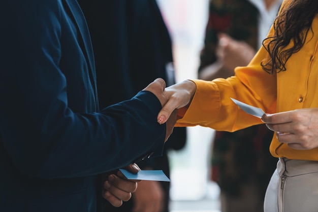 Photo businessmen shaking hand and making a contract in the sign of agreement cooperation with businesswoman cropped image of managers holding business cards their partners standing behind intellectual