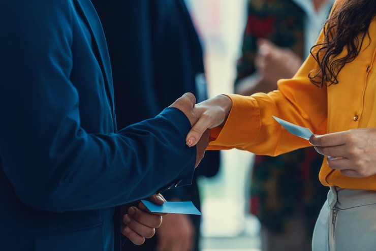 Photo businessmen shaking hand and making a contract in the sign of agreement cooperation with businesswoman cropped image of managers holding business cards their partners standing behind intellectual