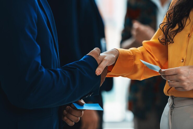 Photo businessmen shaking hand and making a contract in the sign of agreement cooperation with businesswoman cropped image of managers holding business cards their partners standing behind intellectual