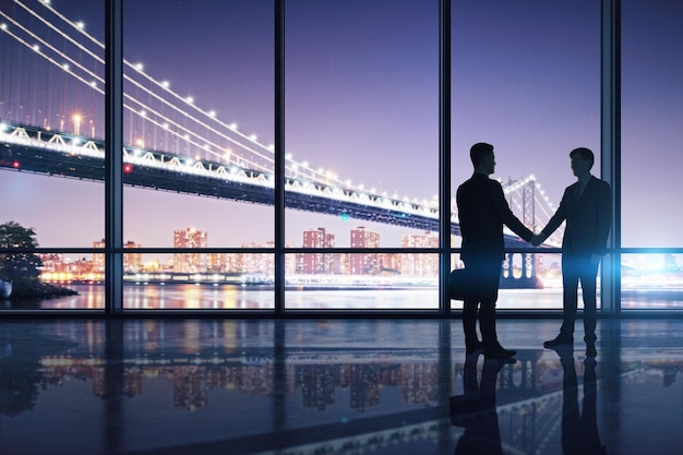 Businessmen shaking hands in modern interior