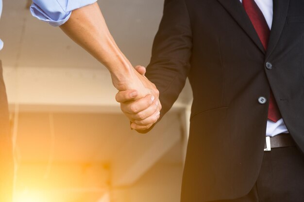 Бизнесмены пожимают друг другу руки в офисе.