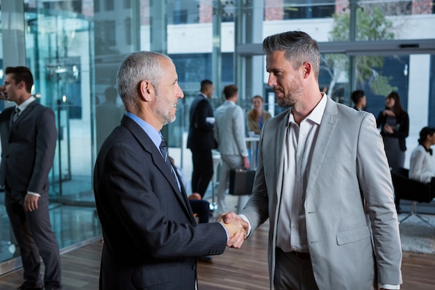 Businessmen shaking hands at office