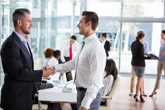 Businessmen shaking hands at office