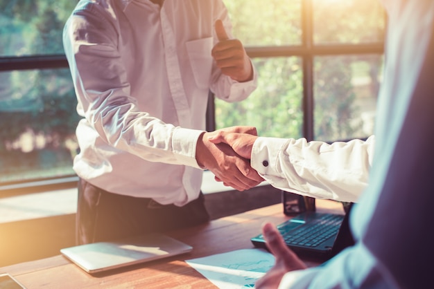 Photo businessmen shaking hands in the office.