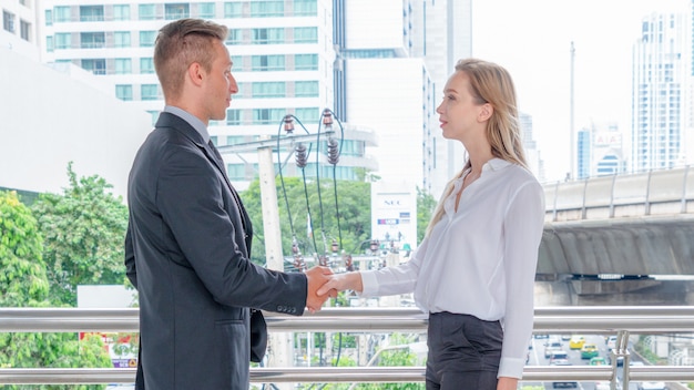 Businessmen Shaking Hands with lady at outdoor space.