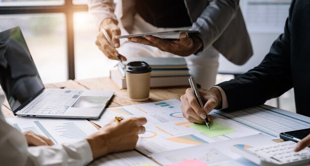 Businessmen team or financial data analysts working with tablets and laptop computers and data graphs together Plan to analyzing projects in the office