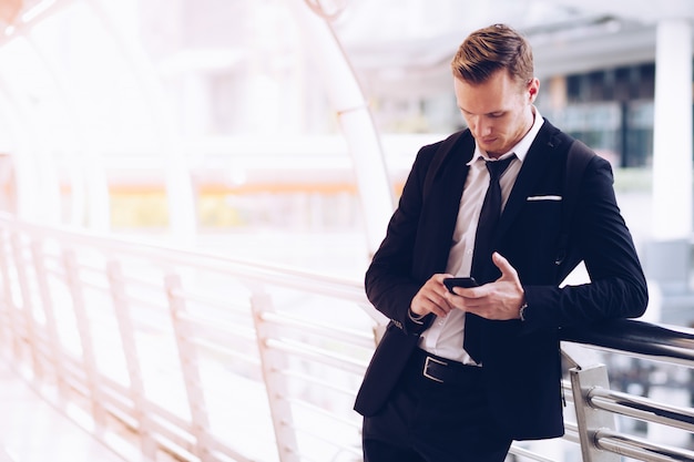 Businessmen use smartphones to call cars.