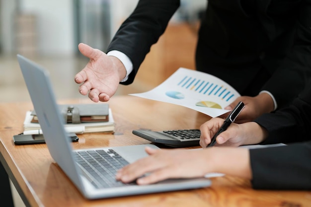 Businessmen working discussing analyzing using laptop and graphs